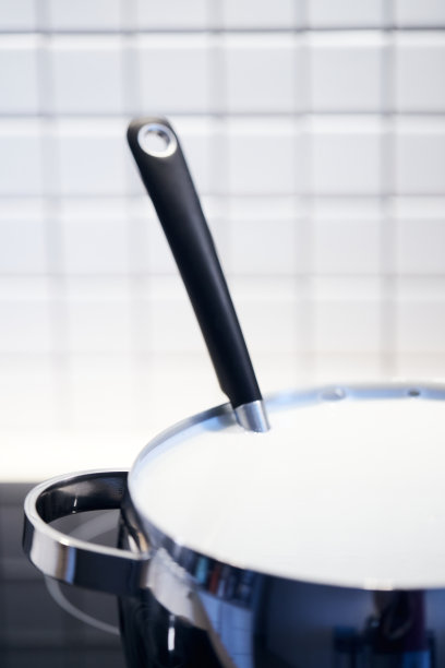 制作酸奶的过程牛奶是由细菌加热和发酵的。牛奶在炉子上的锅里。图片下载