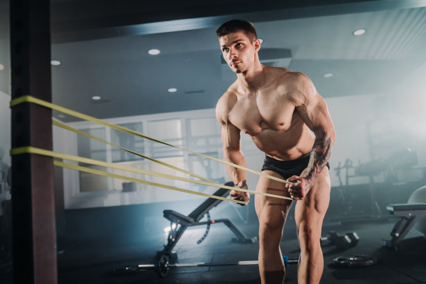 肌肉发达的运动员在健身俱乐部用阻力带做伸展运动图片下载