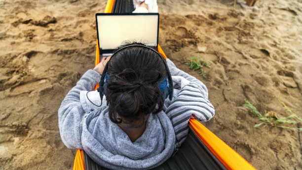 白领女性在吊床上工作，带着笔记本电脑度假图片下载