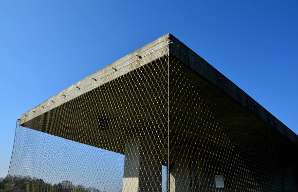 不锈钢网的方形混凝土庇护所。用带扣编织在一起的绳网。凉棚，防鸽子的阳台。攀援植物覆盖和遮荫图片下载