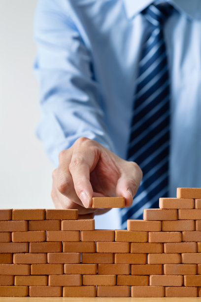 商人把玩具砖放在墙上图片下载