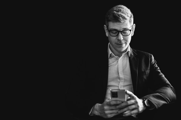 商人在阴影中思考看阅读商业信息智能手机屏幕与拷贝空间背面和白色复古色调。图片下载