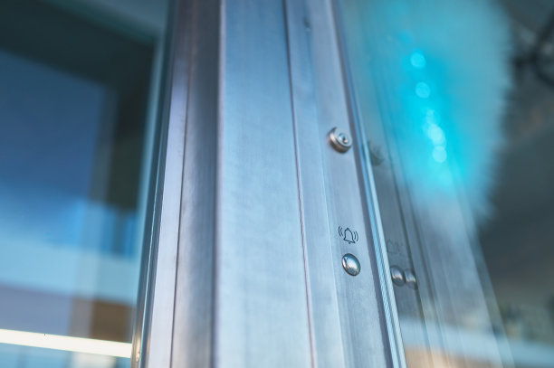 现代建筑中带有门铃的金属和玻璃门图片下载