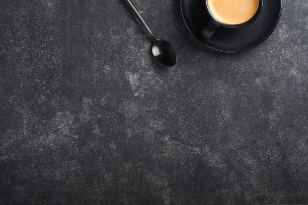 咖啡的背景。在旧的黑色混凝土桌子上，放着测量勺子、咖啡粉、咖啡豆、杯子和甜巧克力松露。食品的背景。带文本空间的俯视图。图片下载