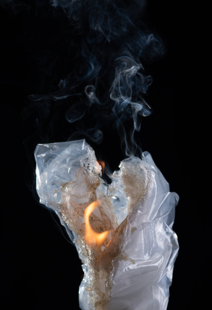 黑色背景上的火正在燃烧塑料袋。图片下载