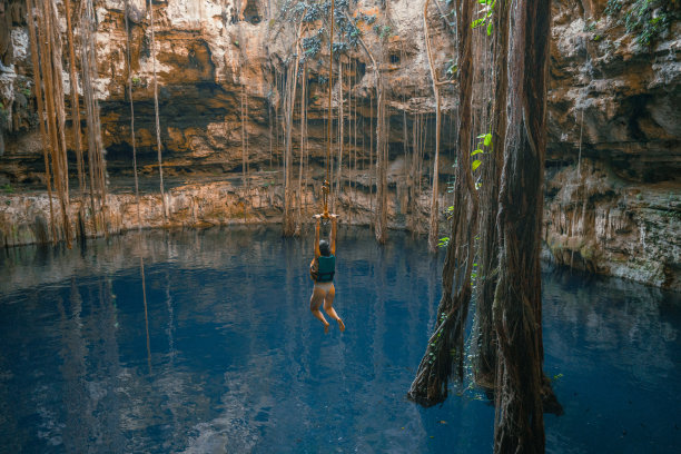 在天然井中荡秋千的女人图片下载
