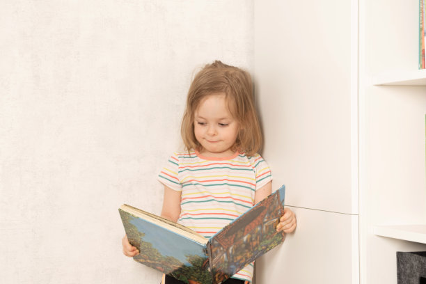 女孩拿着一本书，看着它图片下载