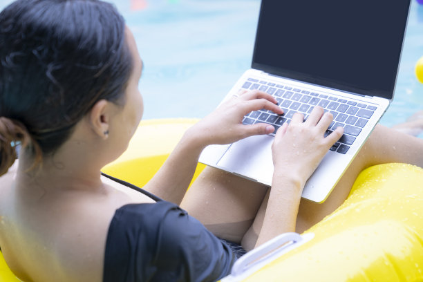 女性在游泳池使用电脑笔记本电脑图片下载