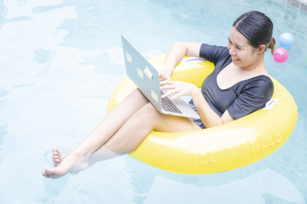 女性在游泳池使用电脑笔记本电脑图片下载
