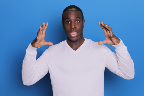 年轻的非洲裔美国人的室内照片被孤立的蓝色背景与手接近头部图片下载