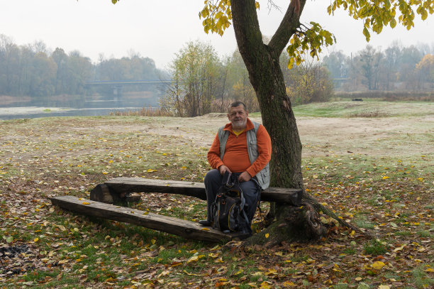 乌克兰萨姆斯卡亚州，秋天的大海，孤独的老年游客在树下短暂休息图片下载