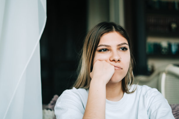 年轻无聊的千禧一代女性独自坐在家里的地板上。疲劳或情感枯竭的概念图片下载