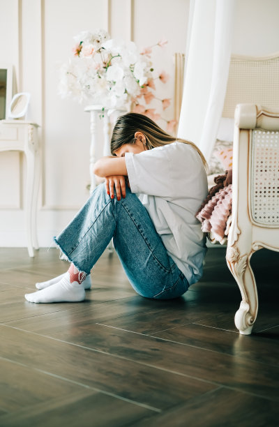 年轻无聊的千禧一代女性独自坐在家里的地板上。疲劳或情感枯竭的概念图片下载