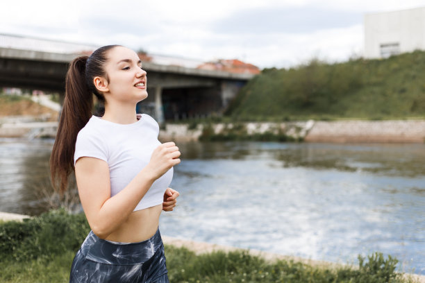 女孩在阴天的河边跑步图片下载