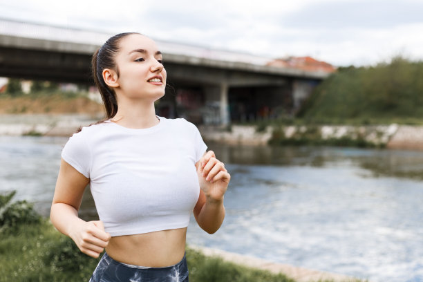 女孩在阴天的河边跑步图片下载