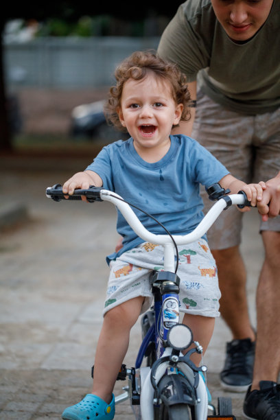 小男孩，在公园里学习骑自行车图片下载