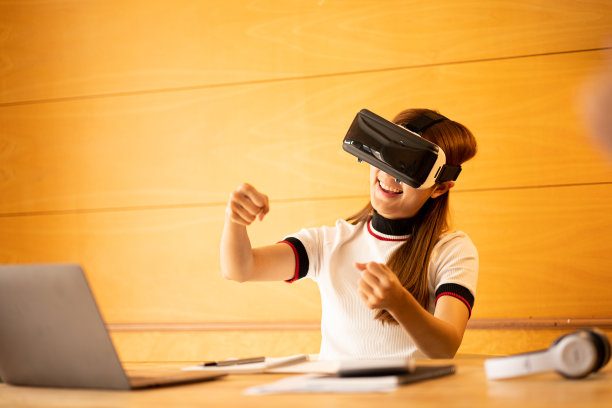 快乐的白人女性戴着虚拟现实眼镜在家里女孩玩与眼镜与手在设备上做出想象的手势。图片下载