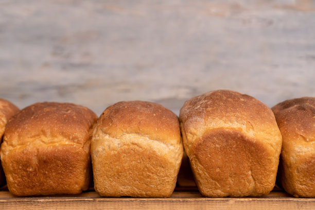 木头架子上新鲜出炉的面包的特写，正面视图。烘焙产品生产图片下载