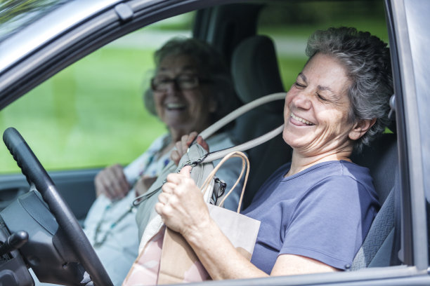年老的成年女儿和年老的母亲在车里笑图片下载