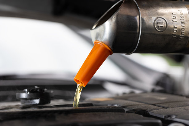 汽车修理厂机械师在汽车维修过程中添加机油的特写图片下载