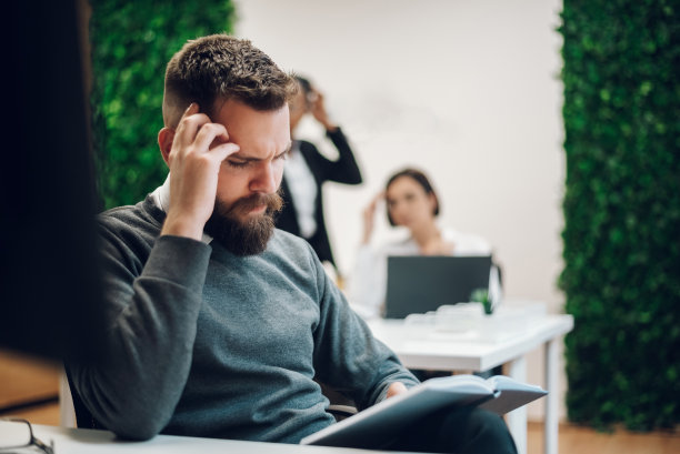 坐在笔记本电脑前，在办公室里头痛的商人图片下载