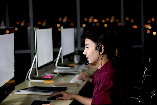 快乐的亚洲男人在呼叫中心服务台与队友一起工作图片下载