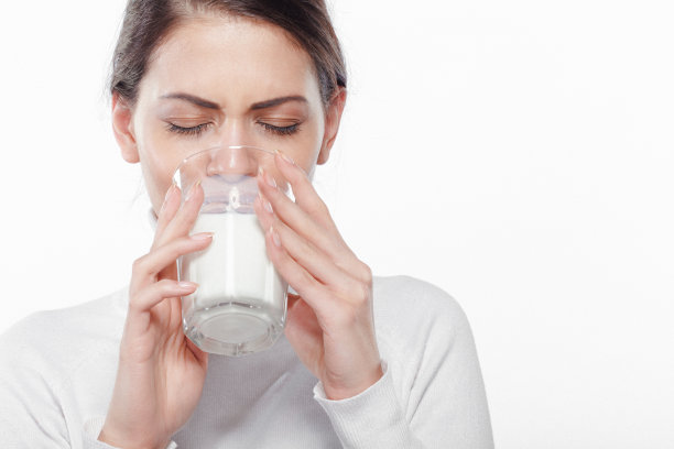 美丽的年轻女子正在享受一杯牛奶图片下载
