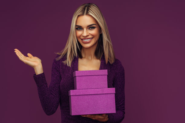 年轻漂亮的女人，完美的头发拿着一个礼物容器图片下载