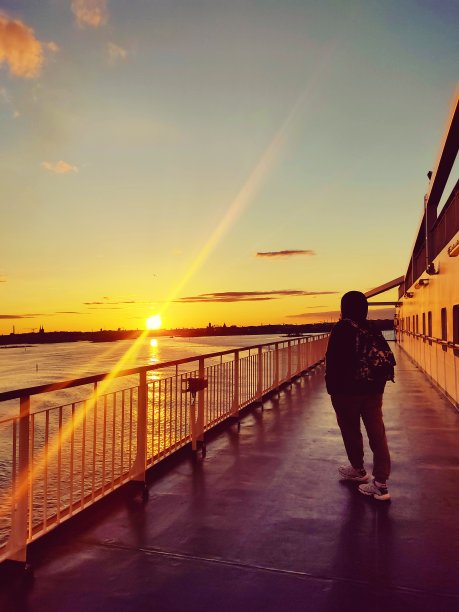 日落时分在渡轮甲板上的人。图片下载