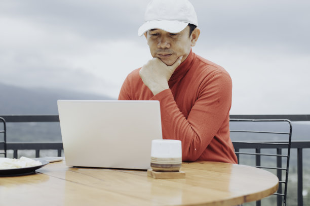 坐在咖啡店里用笔记本电脑的年轻人图片下载