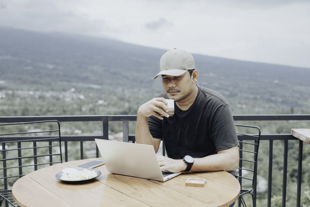 坐在咖啡店里用笔记本电脑的年轻人图片下载