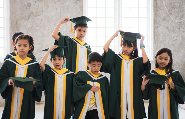 儿时的学生和朋友穿着毕业礼服图片下载