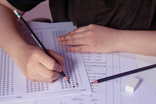 学生用手握着铅笔在答题纸上写下选择的答案图片下载