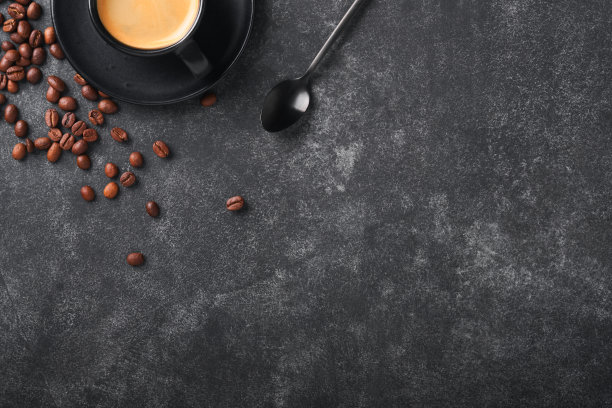 咖啡的背景。在旧的黑色混凝土桌子上，放着测量勺子、咖啡粉、咖啡豆、杯子和甜巧克力松露。食品的背景。带文本空间的俯视图。图片下载