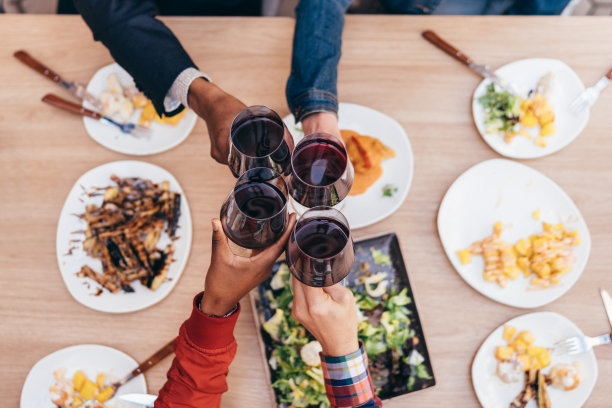 4个不同民族的手用红酒干杯图片下载