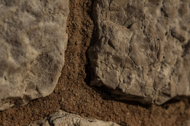 沙地里一块石头的特写。沙子里有石灰石。鹅卵石图片下载