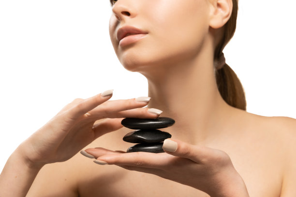 按摩的石头。美丽的女性模型在白色背景。美容、化妆品、水疗、脱毛、饮食、治疗理念图片下载