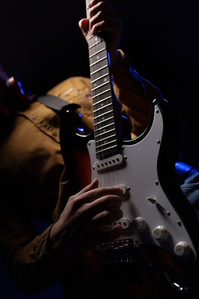 男人弹奏电吉他。音乐人在工作室里拿着电吉他图片下载