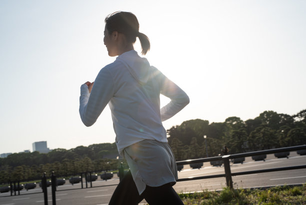 年轻女子在城市街道上奔跑图片下载