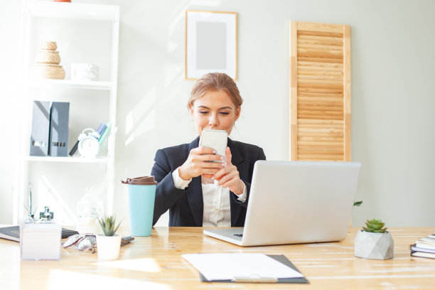 快乐的女商人在办公室用智能手机发送消息图片下载