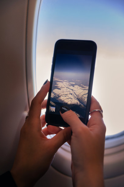 女人在飞机上用智能手机拍照片图片下载