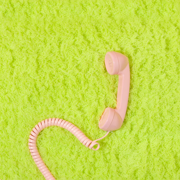 粉彩粉色复古电话听筒霓虹灯绿色蓬松蓬松的地毯背景。80年代或90年代的复古美学时尚背景。浪漫的交流想法。图片下载
