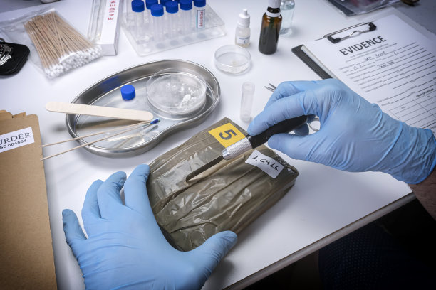 专门的警察在犯罪实验室打开一捆毒品，概念图像图片下载