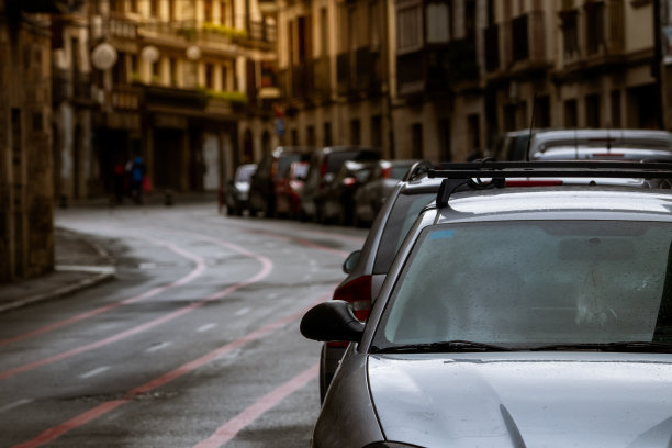 欧洲城市沿街停放的一排汽车和古老的建筑。许多汽车停在老城区的路上。欧洲的城市街道。住宅楼外停放的汽车的正面视图。城市交通。图片下载