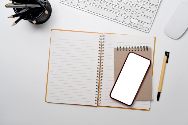 手机，笔记本，笔筒和无线键盘上的白色背景。前视图。图片下载