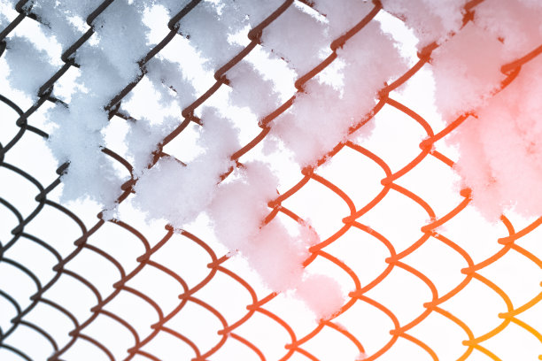 铁栅栏上的雪在明亮的阳光下作背景。春天就要来了。图片下载