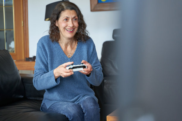 老妇人在玩游戏时微笑图片下载