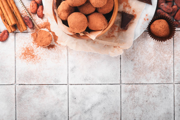 巧克力松露与可可粉在木制盘子在旧裂瓦桌子背景。美味甜美的巧克力松露糖果。情人节和母亲节的概念与拷贝空间。前视图。图片下载