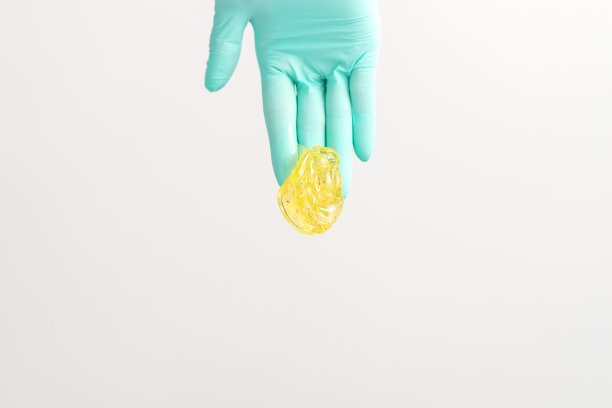 黄糖膏在手，掌握脱毛。微笑的美容师持有蜡脱毛的白色背景。拔毛的概念。图片下载