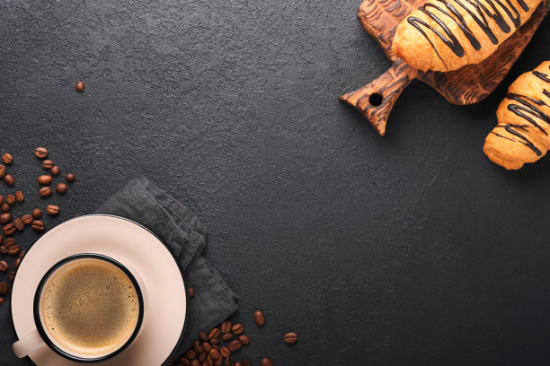 咖啡和羊角面包。浓咖啡和巧克力羊角面包放在旧的黑色混凝土桌子上。完美的羊角面包早餐。乡村风格。前视图。模拟。图片下载